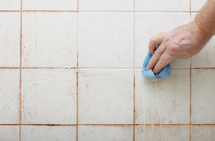 cleaning dirty shower and bathroom tiles with mould