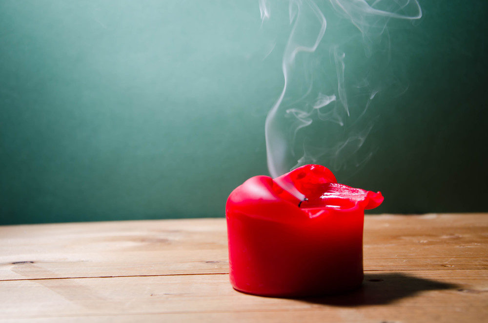 Smoke coming from melted red candle